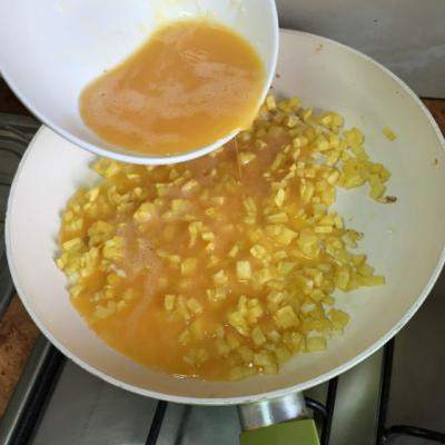 Adauga ouale batute peste cartofii cubulete din tigaie. Ce face apoi? DELICIOS